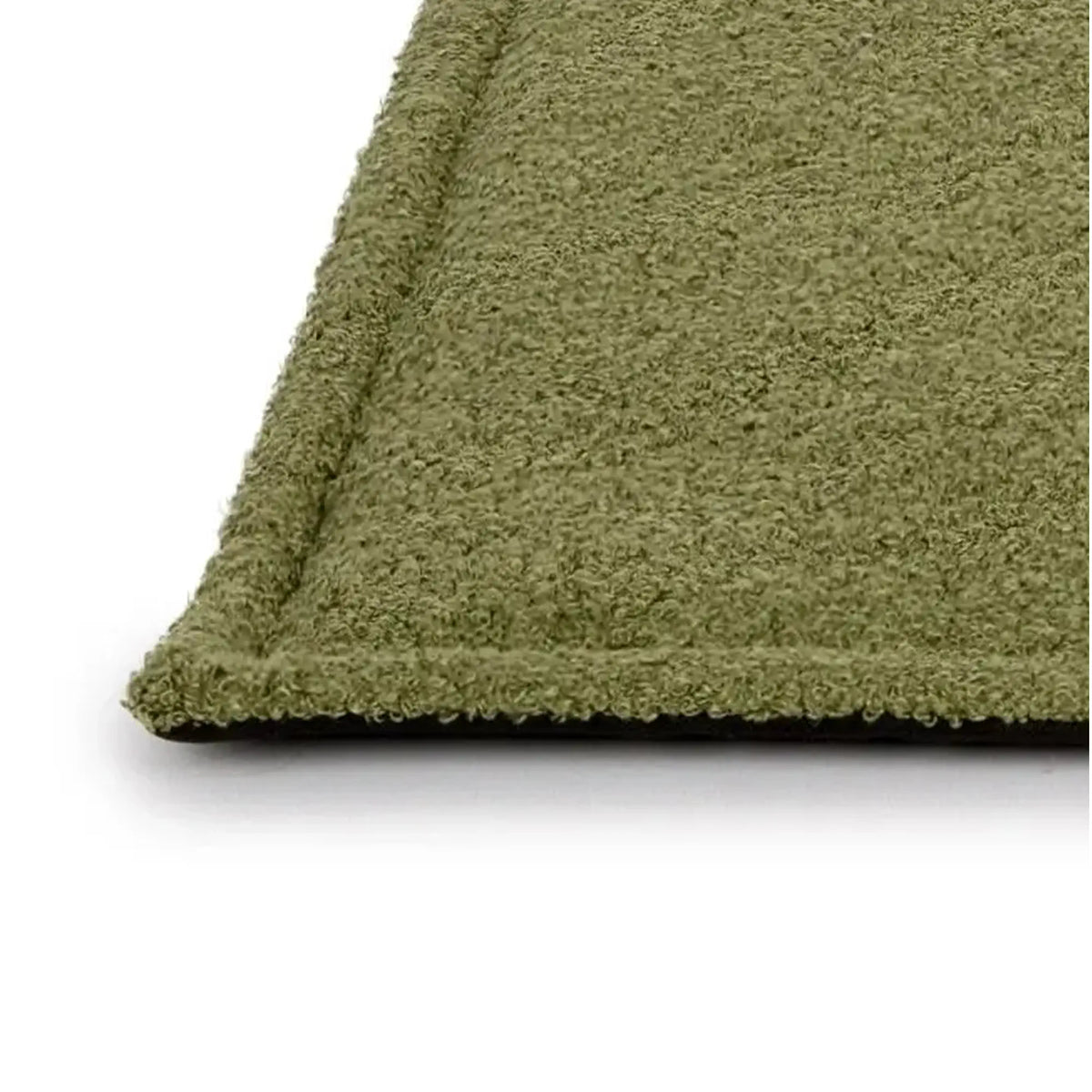 Close-up van de afgewerkte rand en zachte bouclé bovenkant van de fluffy hondenmat Soffice in groen